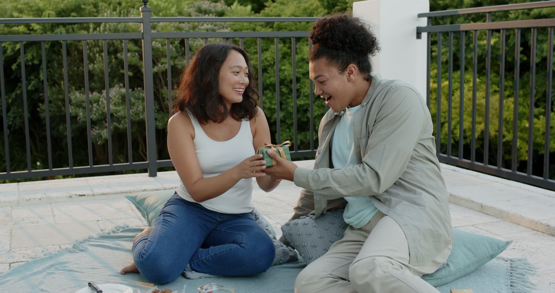 Couple Enjoying Relaxing Rooftop Picnic Date Sharing Snacks