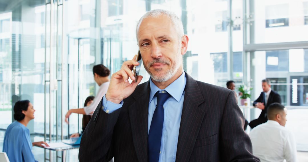 Confident Senior Businessman Speaking on Phone in Modern Office - Free Images, Stock Photos and Pictures on Pikwizard.com