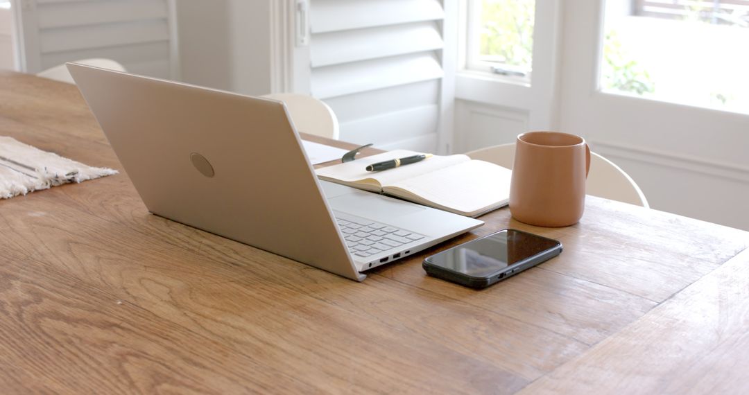 Modern Workspace with Laptop and Notebook on Wooden Table