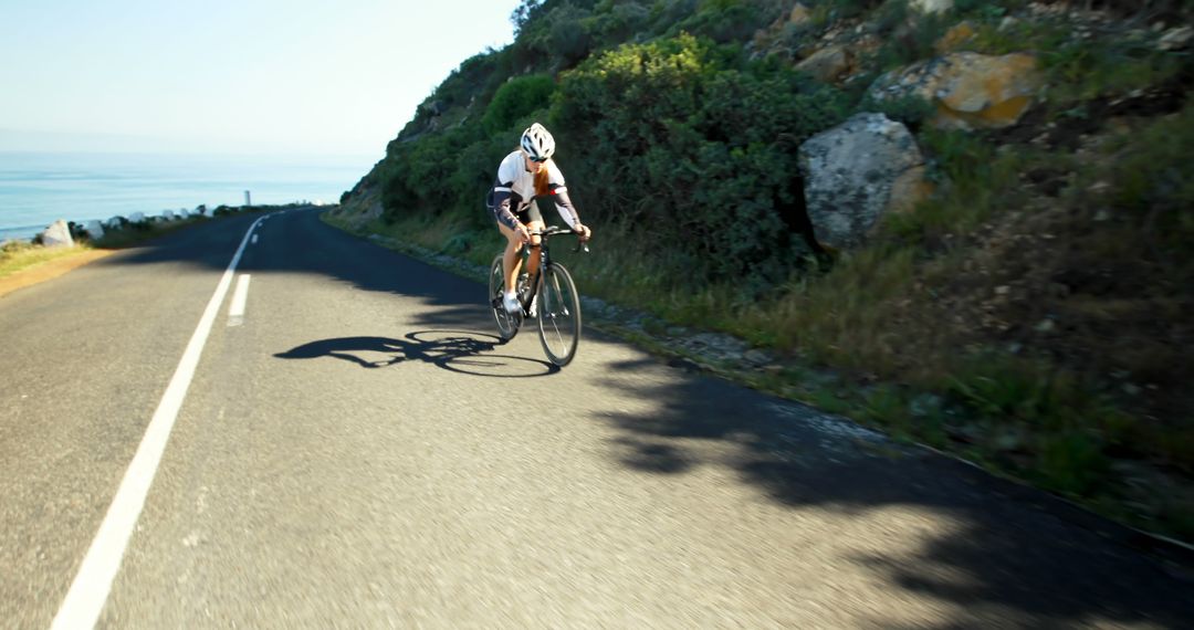 Cyclist Riding on a Mountain Road in Sunlight - Free Images, Stock Photos and Pictures on Pikwizard.com