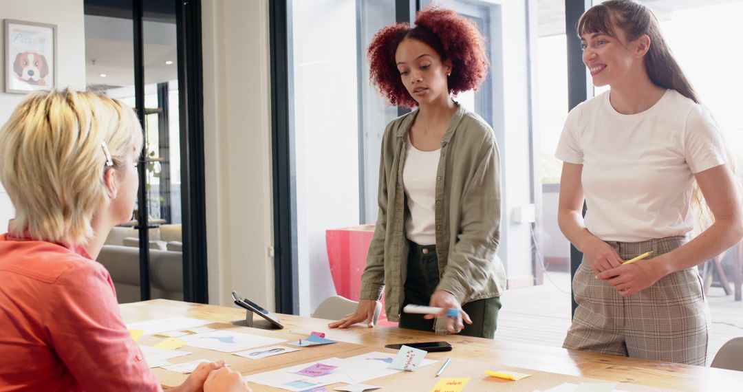Diverse Team Brainstorming at Conference Table with Sticky Notes and Tablet