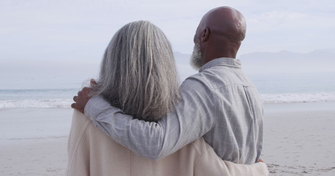Senior Couple Embracing While Enjoying Serene Beach View - Free Images, Stock Photos and Pictures on Pikwizard.com