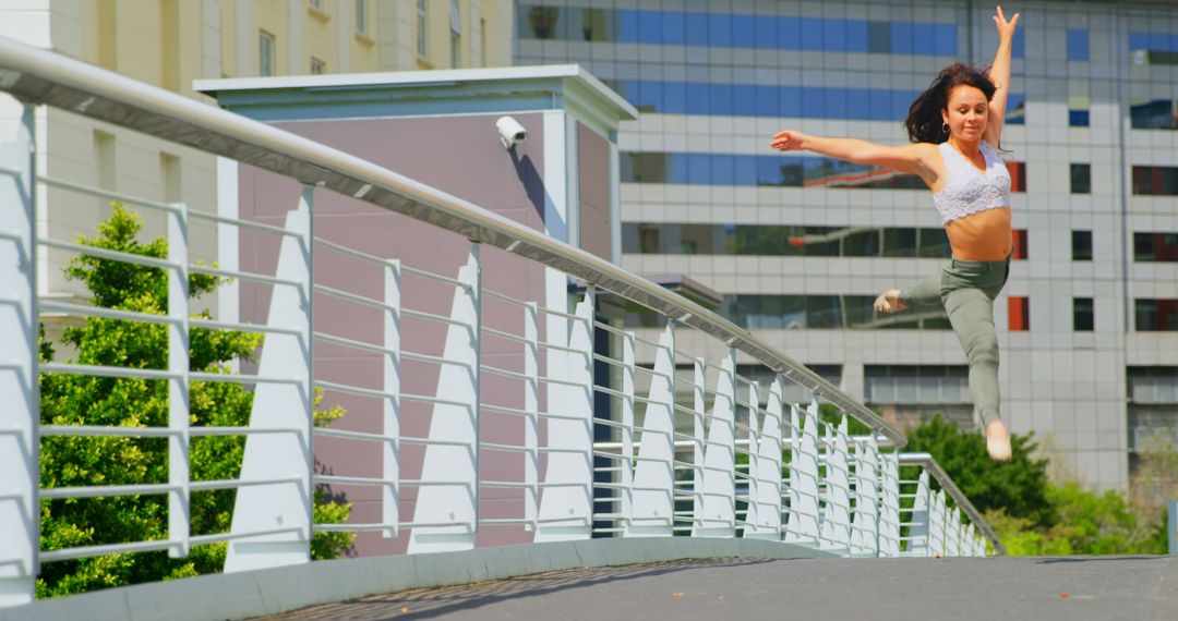 Energetic female dancer practicing ballet on urban bridge
