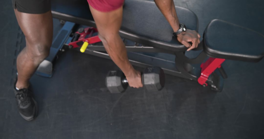 Man Performing One-Arm Dumbbell Row Exercise at Gym