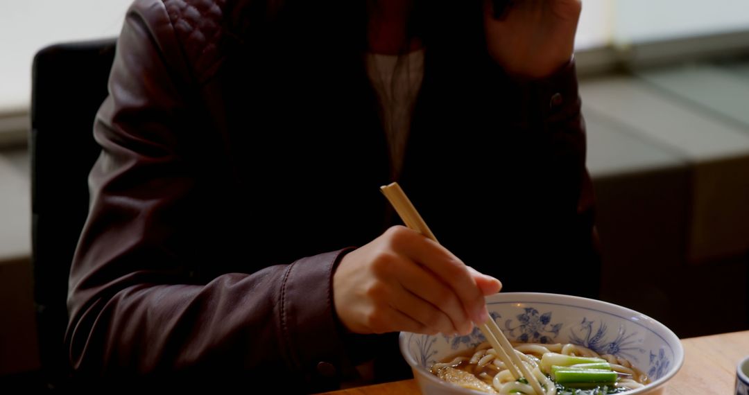 Person Eating Noodle Soup with Chopsticks in Casual Setting - Free Images, Stock Photos and Pictures on Pikwizard.com