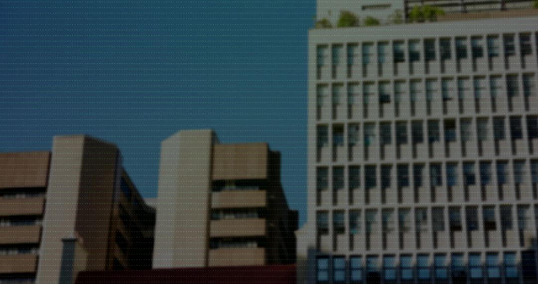Midrise urban buildings lining city street with recessed windows and grid facade