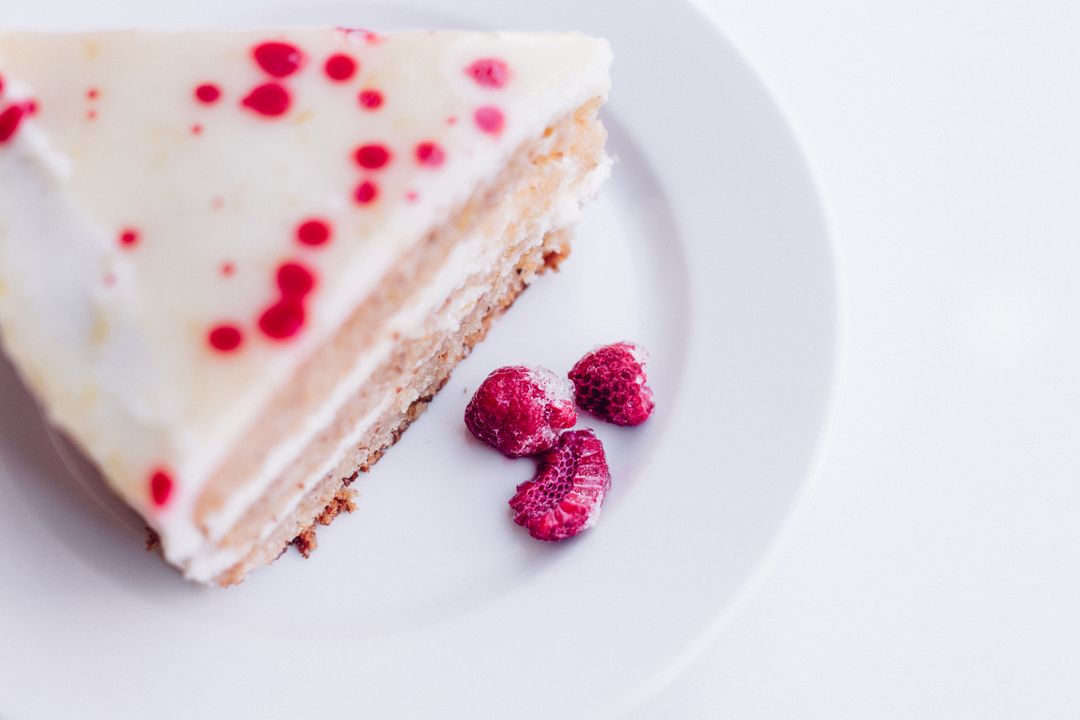 Slice of raspberry vanilla cheesecake on white plate