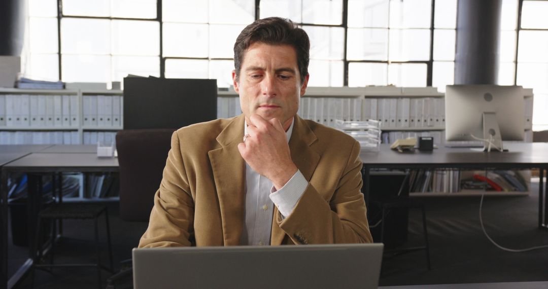 Businessman Concentrating on Laptop for Data Analysis
