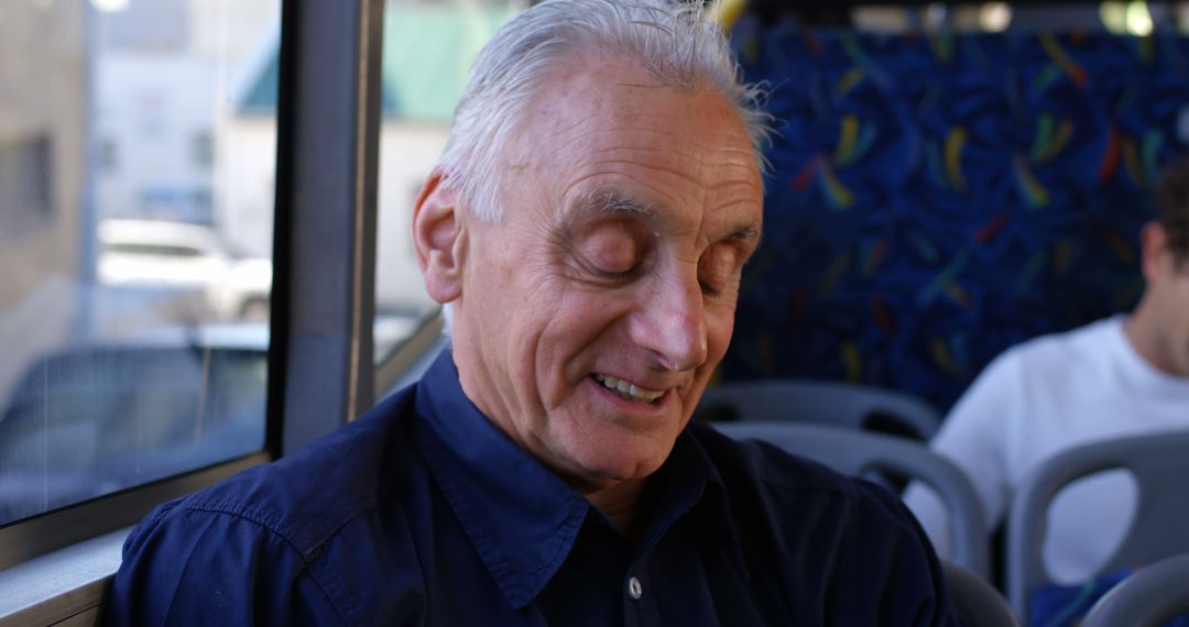 Elderly man smiling while traveling on public transport - Free Images, Stock Photos and Pictures on Pikwizard.com