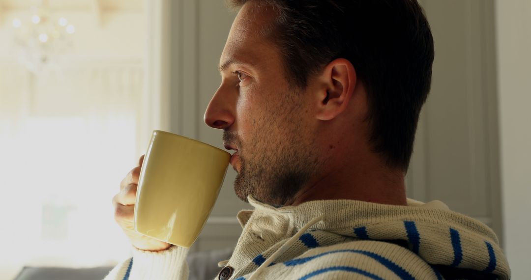 Man sitting at home drinking coffee, relaxed and thoughtful - Free Images, Stock Photos and Pictures on Pikwizard.com