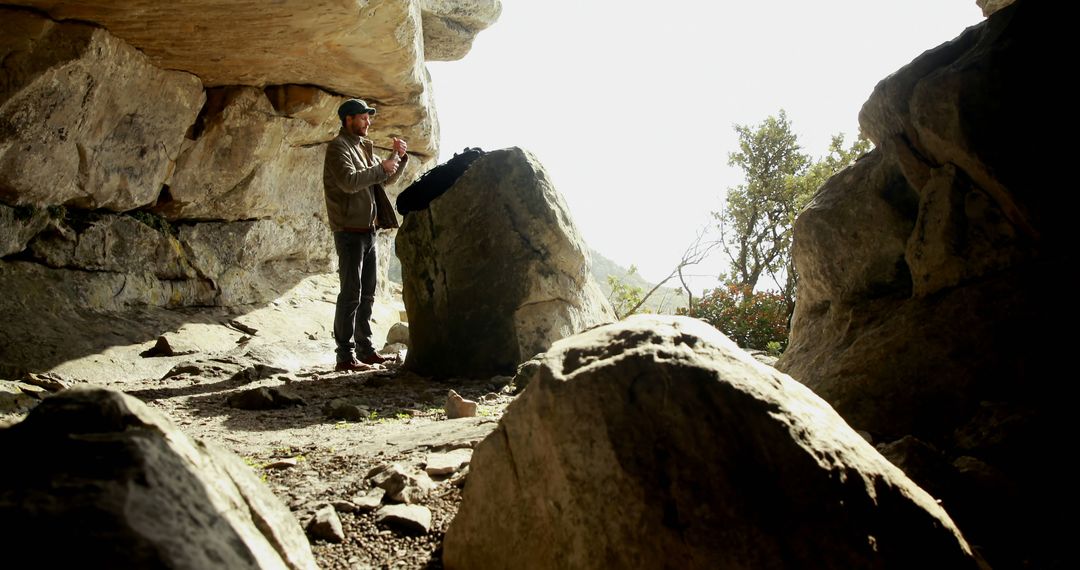 Man Drawing on Rock Inside Sunlit Cave - Free Images, Stock Photos and Pictures on Pikwizard.com