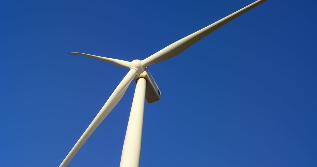 Low Angle View of Wind Turbine Against Clear Blue Sky