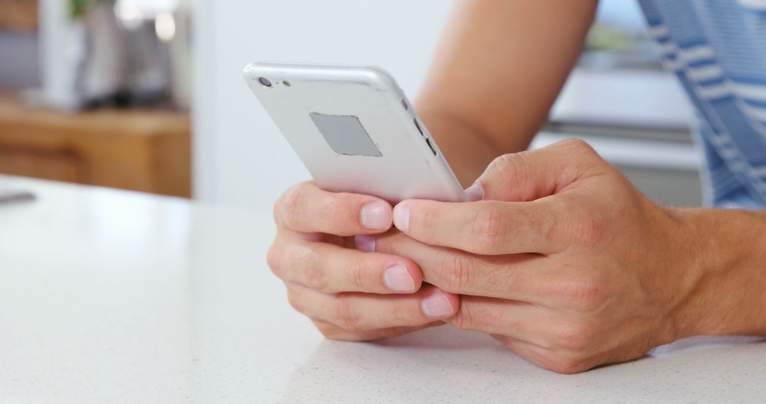 Close-up of person using smartphone at home on counter - Free Images, Stock Photos and Pictures on Pikwizard.com