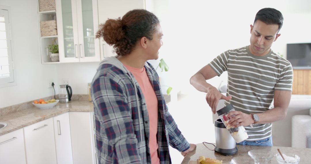 Smiling Gay Couple Making Fruit Smoothie in Kitchen