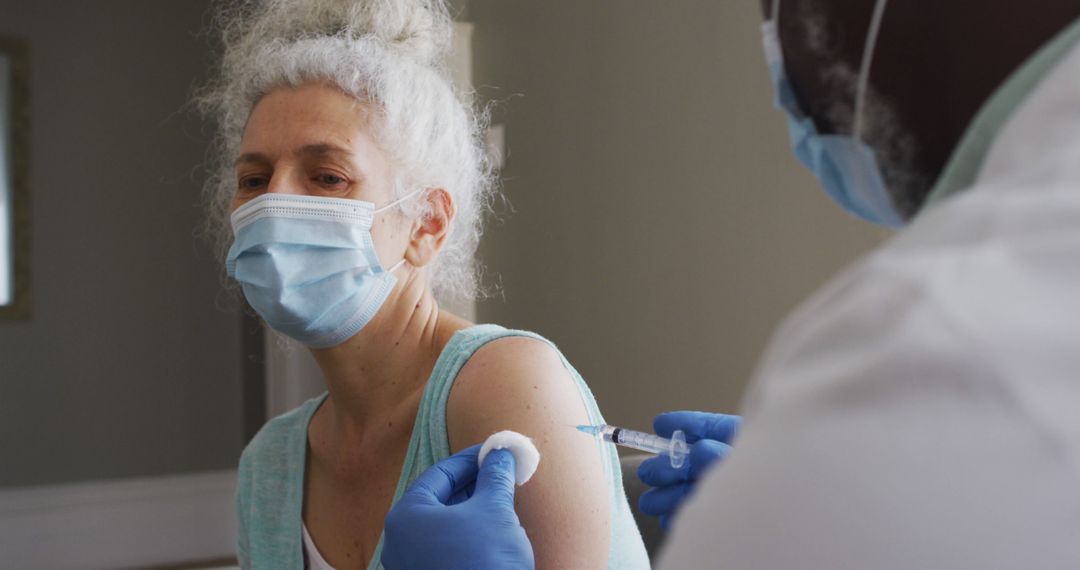 Medical professional administering vaccine shot to elderly woman - Free Images, Stock Photos and Pictures on Pikwizard.com