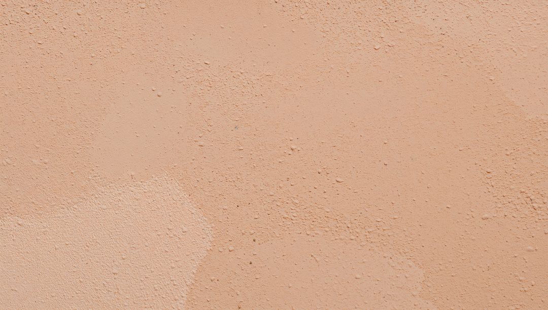 Warm Peach Plaster Texture Close-Up with Granular Bumps and Irregular Patches