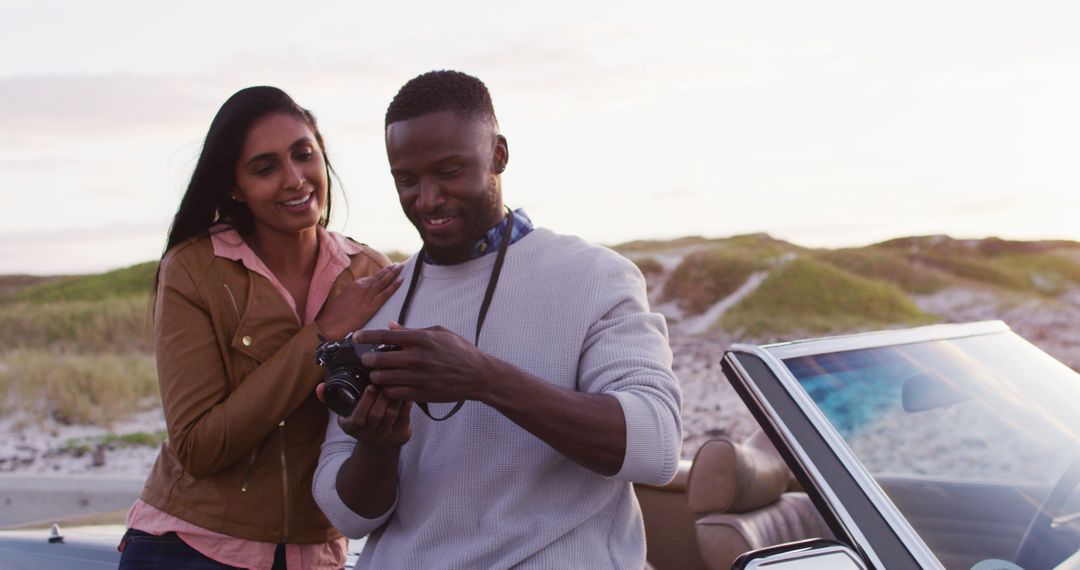 African American couple captures road trip memories with a camera by their convertible. - Free Images, Stock Photos and Pictures on Pikwizard.com