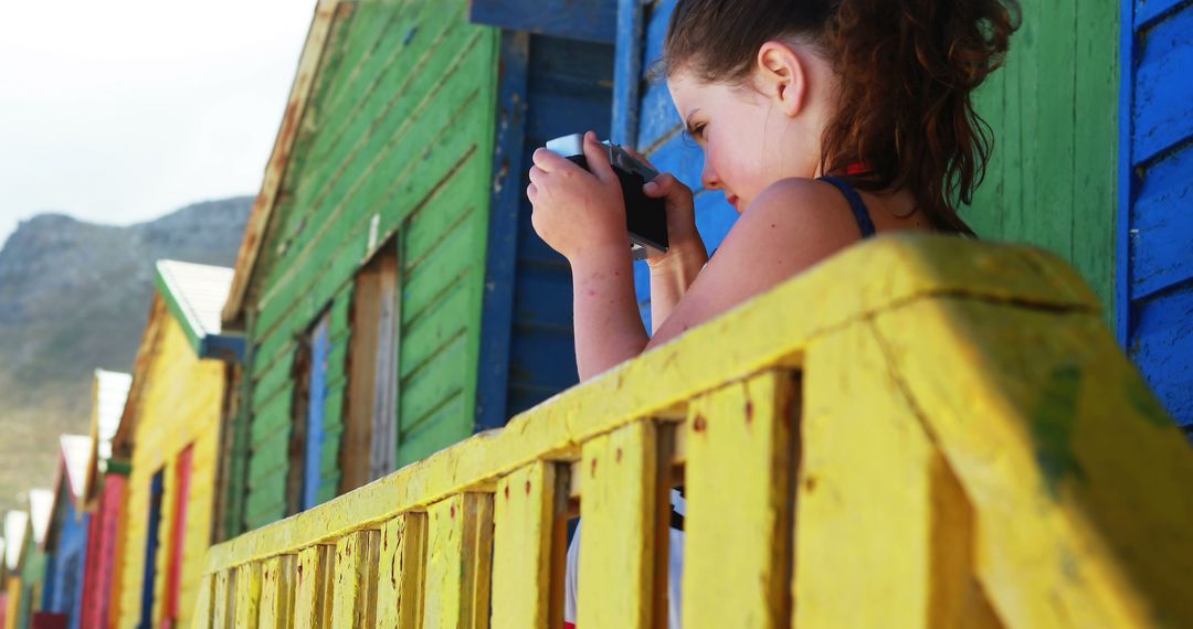 Young Woman Taking Photos of Colorful Beach Huts - Free Images, Stock Photos and Pictures on Pikwizard.com