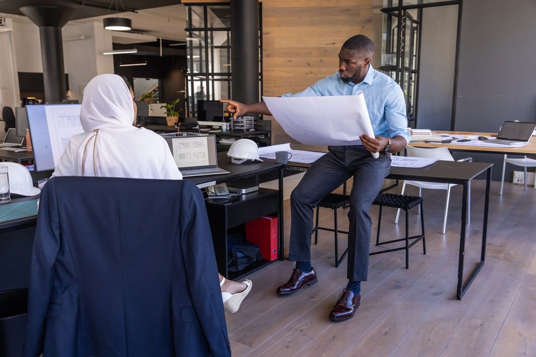 Collaborative Diverse Architects Reviewing Blueprint in Modern Office
