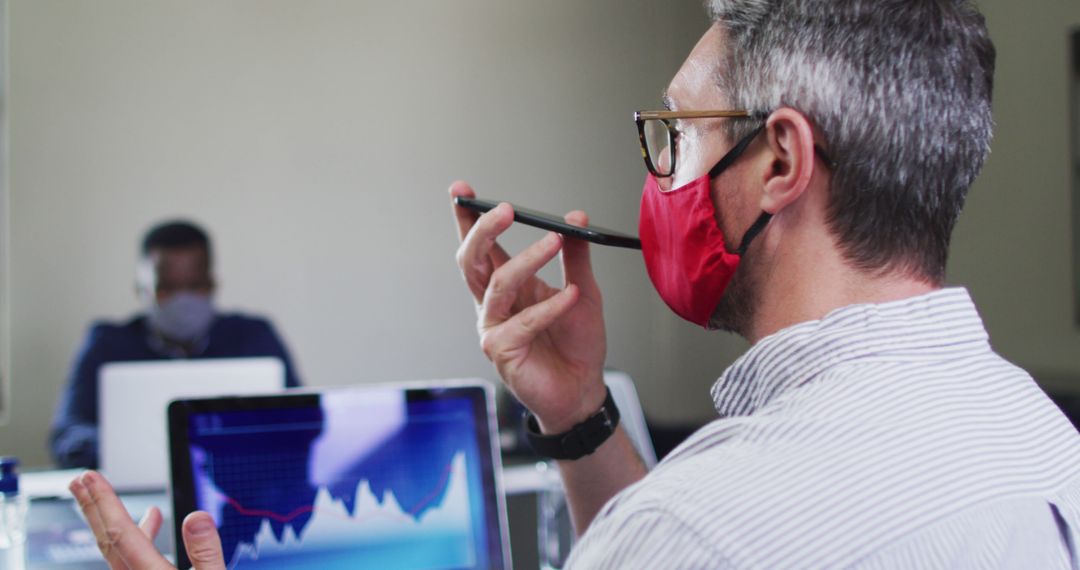 Businessman Wearing Mask Analyzing Financial Data in Office - Free Images, Stock Photos and Pictures on Pikwizard.com