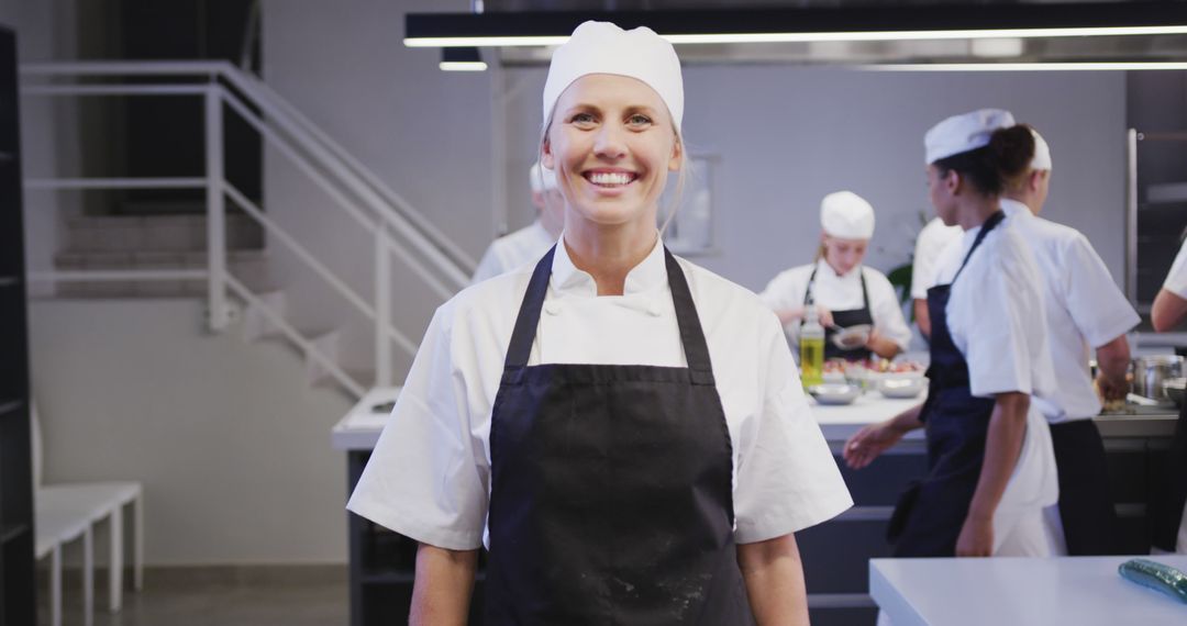 Confident Female Chef Smiling in Commercial Kitchen - Free Images, Stock Photos and Pictures on Pikwizard.com