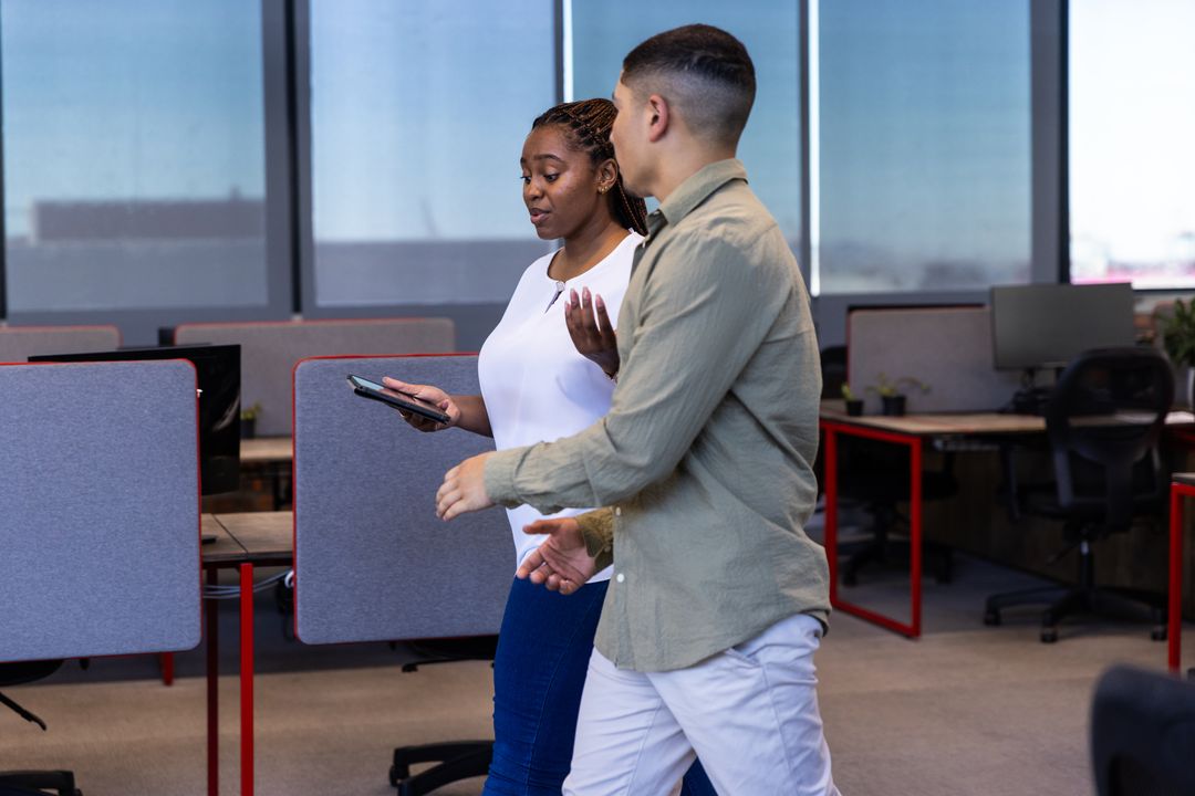 Diverse Coworkers Walking and Talking in Modern Office