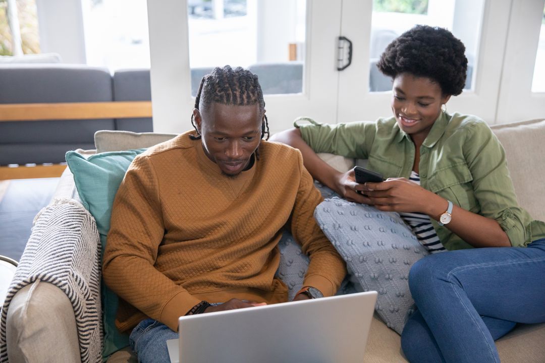 Happy African American Couple Relaxing at Home with Technology