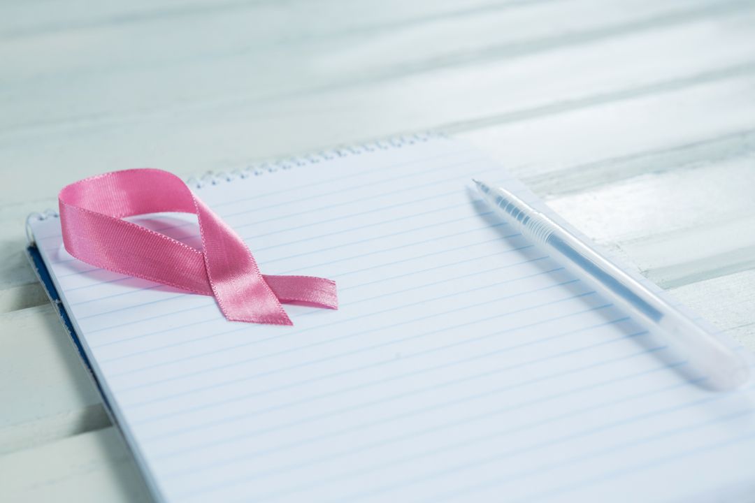 Pink Breast Cancer Awareness Ribbon on Notepad with Pen - Free Images, Stock Photos and Pictures on Pikwizard.com