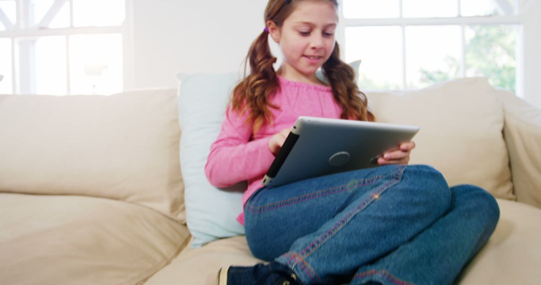 Happy Girl Using Tablet on Couch - Free Images, Stock Photos and Pictures on Pikwizard.com