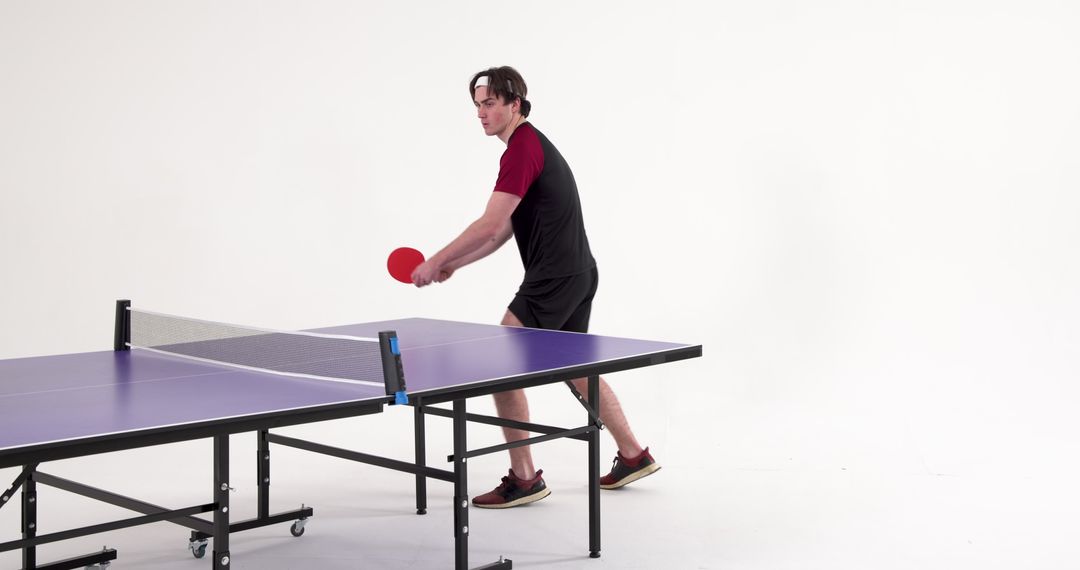 Man Playing Ping Pong on Purple Table Tennis Table