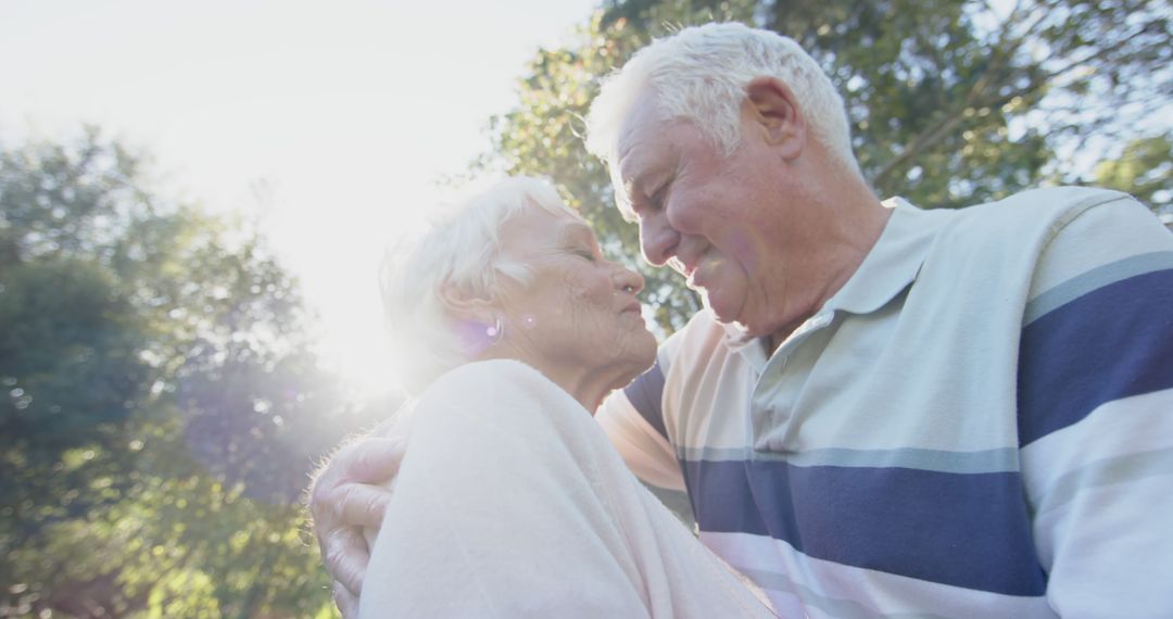 Senior Couple Embracing in Sunlit Garden