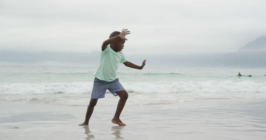 Boy Dancing Joyfully on Sand at Beach - Free Images, Stock Photos and Pictures on Pikwizard.com