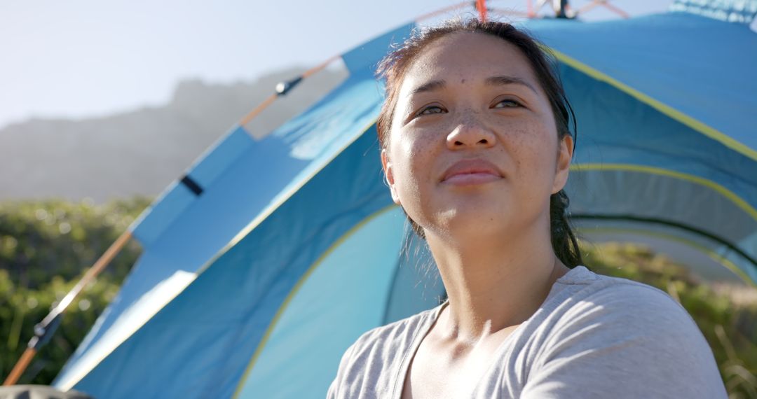 Adventurous Woman Relaxing by Tent on Mountain Getaway