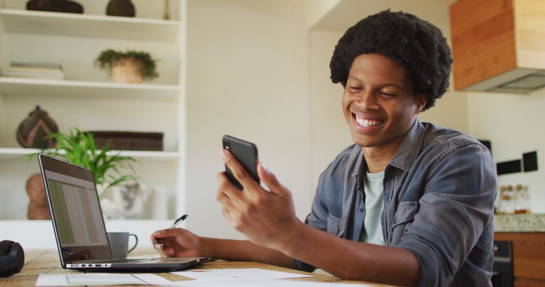 African American Man Working Remote via Laptop and Smartphone