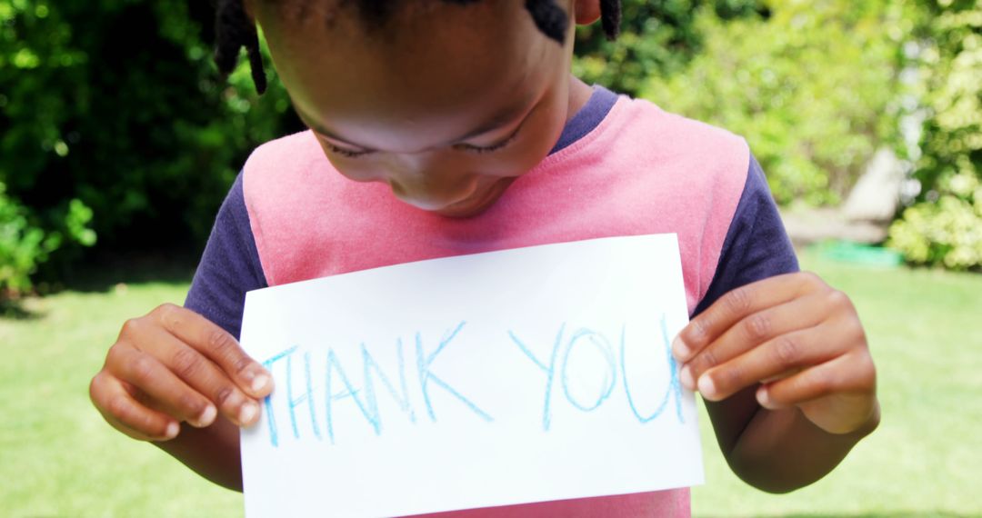 Child Holding 'Thank You' Sign in Garden - Free Images, Stock Photos and Pictures on Pikwizard.com