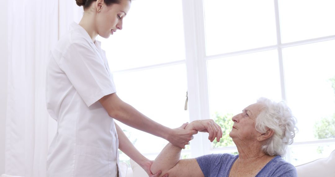 Healthcare Worker Assisting Elderly Woman in Bright Room - Free Images, Stock Photos and Pictures on Pikwizard.com