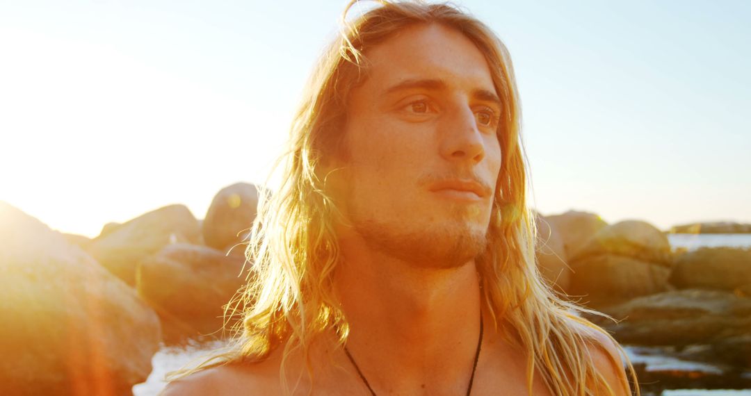 Young Man with Long Hair Looking to Horizon at Sunset - Free Images, Stock Photos and Pictures on Pikwizard.com