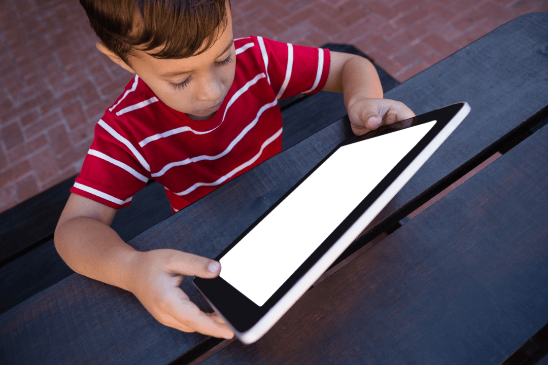 Child Using Transparent Screen Tablet Outdoors at Table