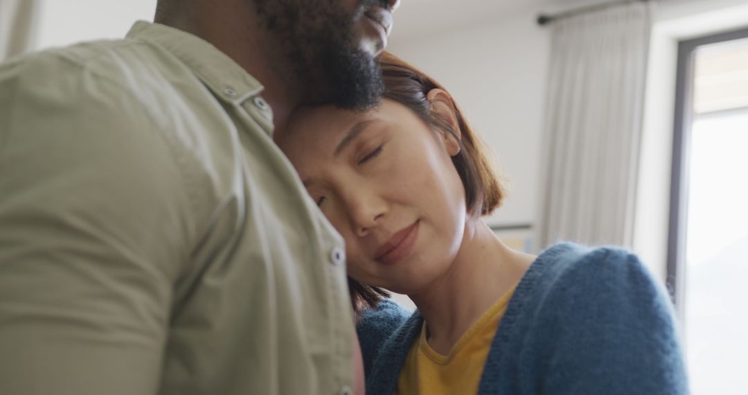 Image of happy diverse couple embracing with eyes closed and smiling at each other at home - Free Images, Stock Photos and Pictures on Pikwizard.com