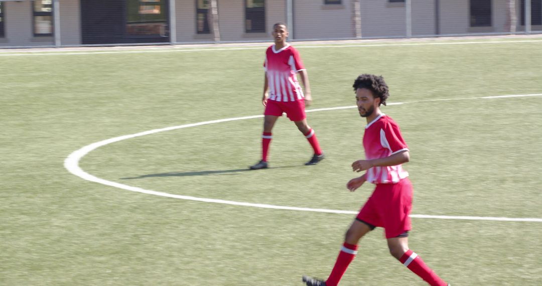 Teen Football Player Practicing on Field During Daytime