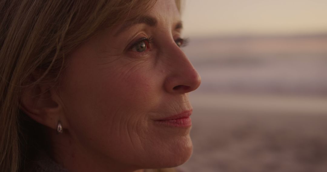 Serene Mature Woman Reflecting by Beach at Sunset - Free Images, Stock Photos and Pictures on Pikwizard.com