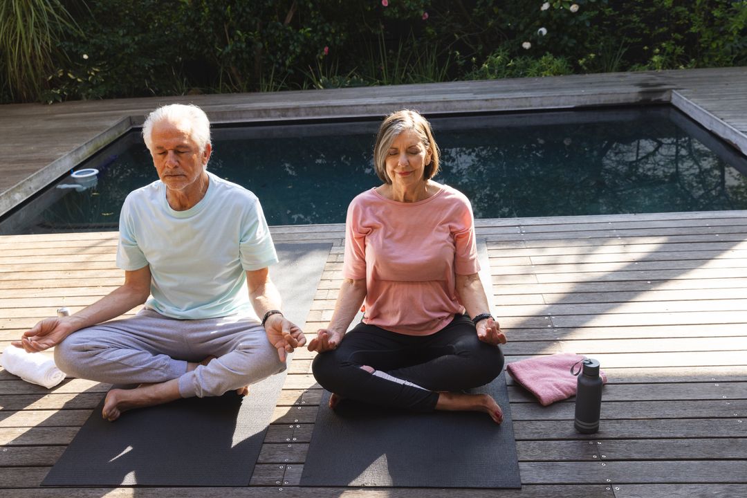 Serene Senior Couple Meditating on Poolside Deck