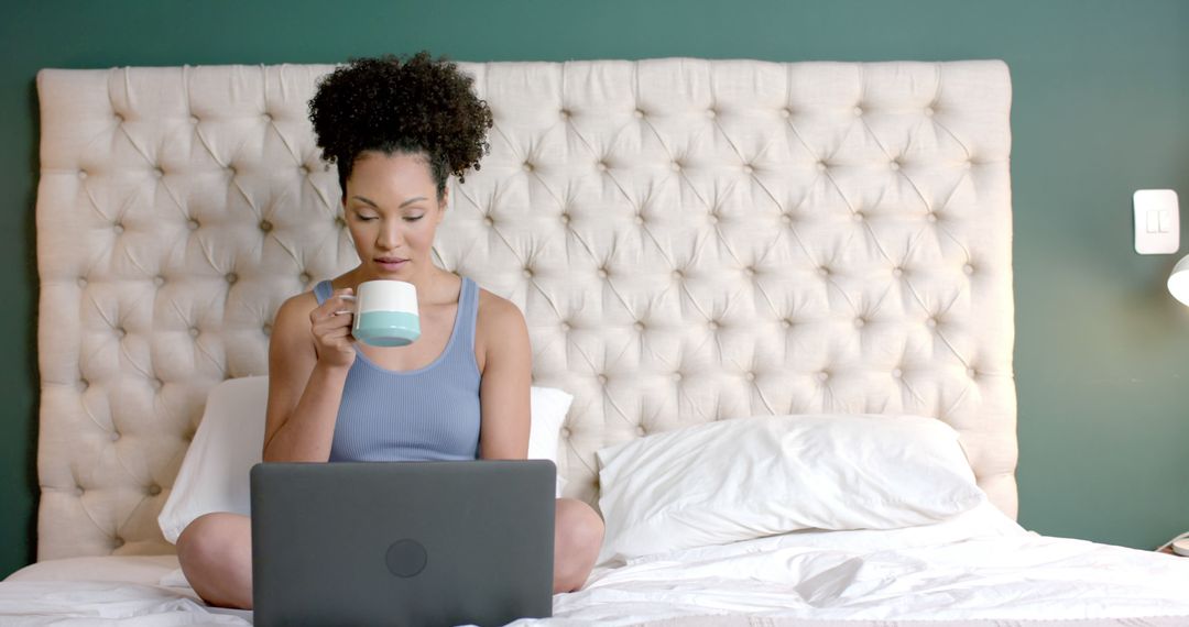 Woman Drinking Coffee While Using Laptop in Bedroom - Free Images, Stock Photos and Pictures on Pikwizard.com