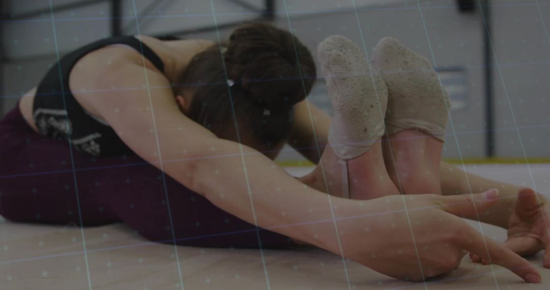 Adolescent Gymnast Practicing Seated Forward Stretch in Studio