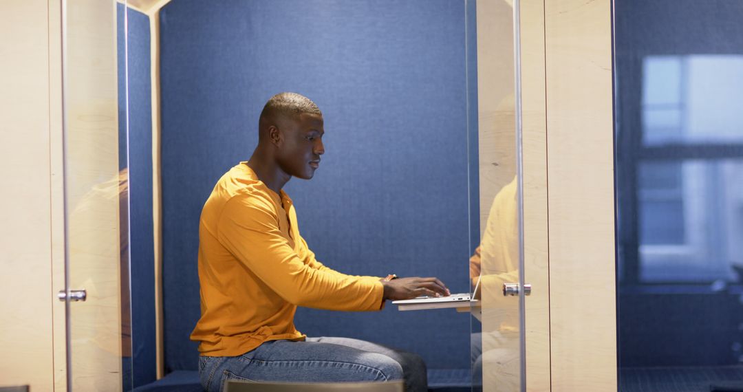 Focused Professional Working on Laptop in Modern Office Pod