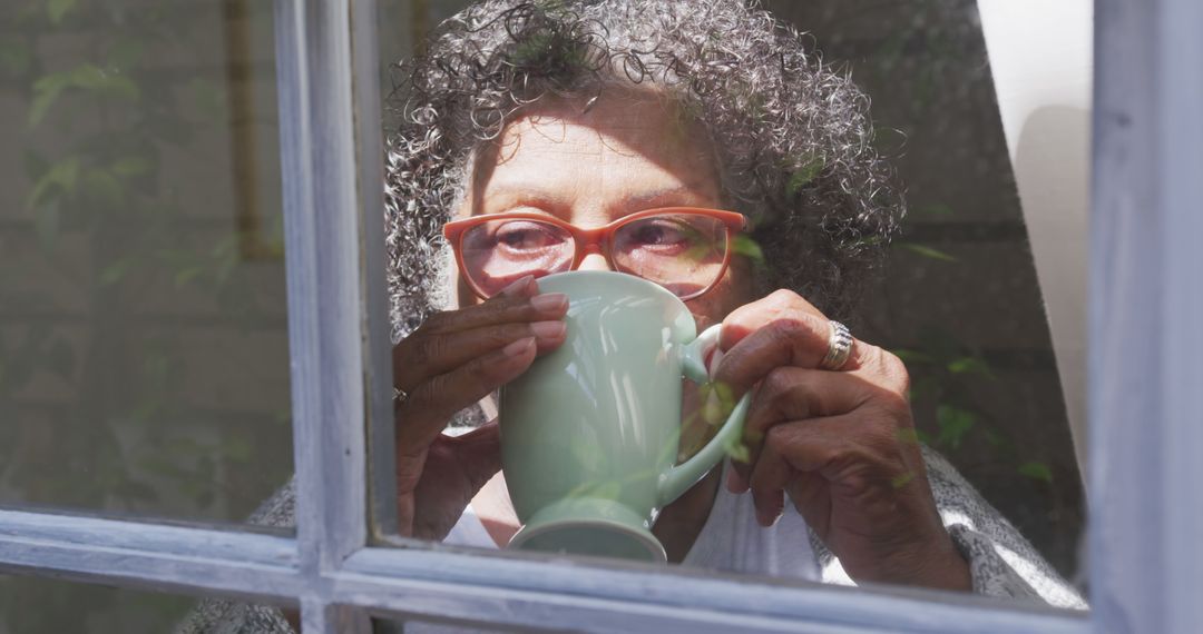 Senior Woman Drinking Tea Looking Through Window - Free Images, Stock Photos and Pictures on Pikwizard.com