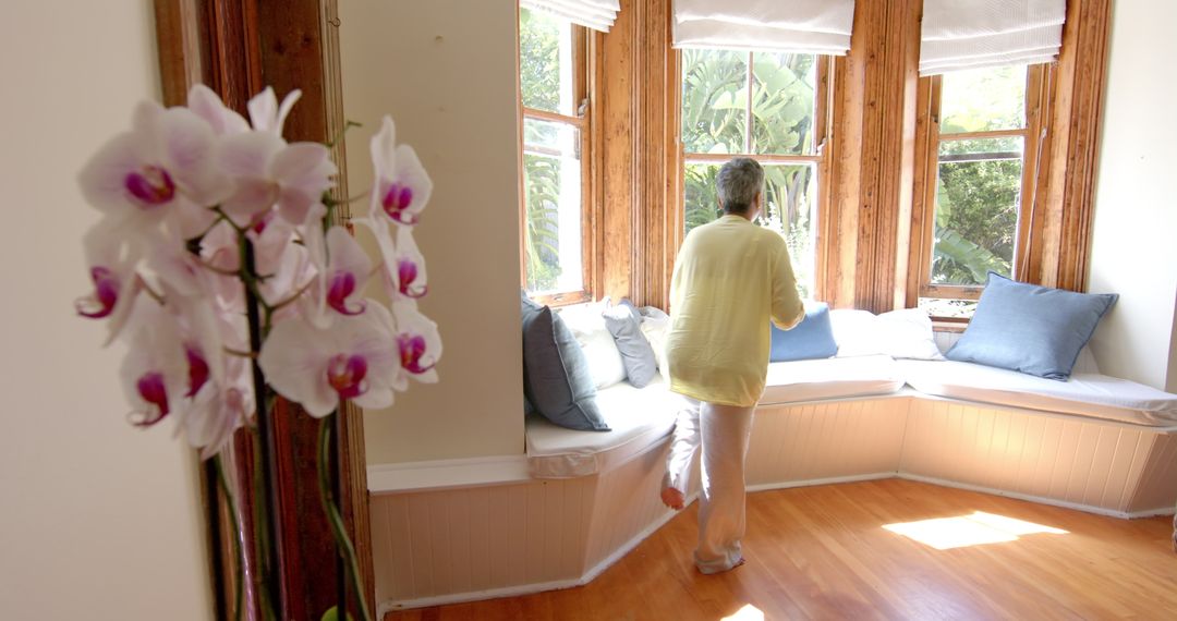 Senior woman relaxing with tea in sunny home corner