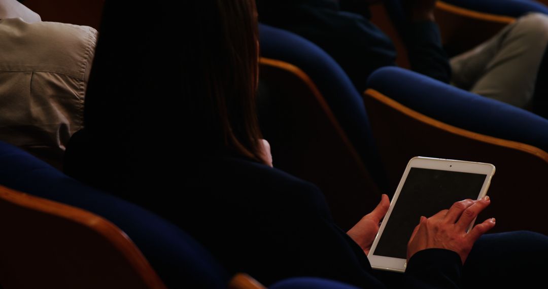 Person Using Tablet in Auditorium for Professional Event - Free Images, Stock Photos and Pictures on Pikwizard.com