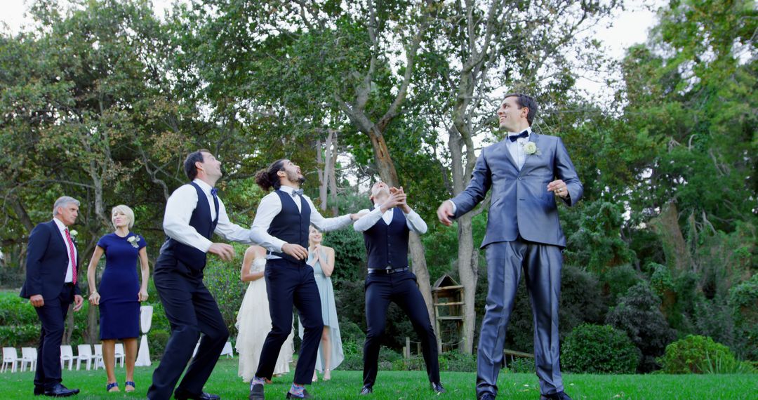 Groom and Guests Watching Tossed Garter at Outdoor Wedding Reception - Free Images, Stock Photos and Pictures on Pikwizard.com