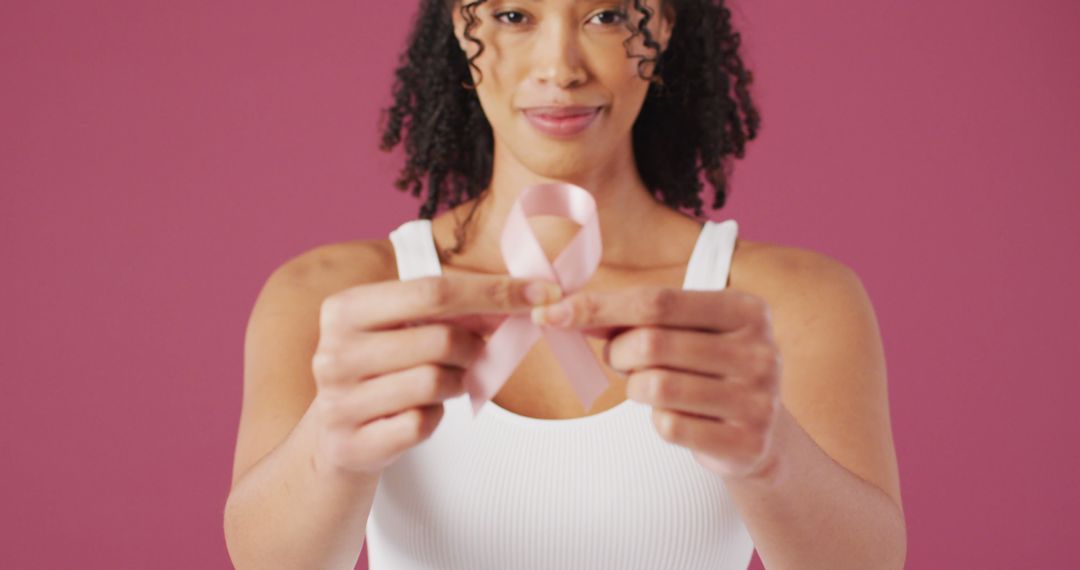 Woman Holding Pink Breast Cancer Awareness Ribbon on Pink Background - Free Images, Stock Photos and Pictures on Pikwizard.com